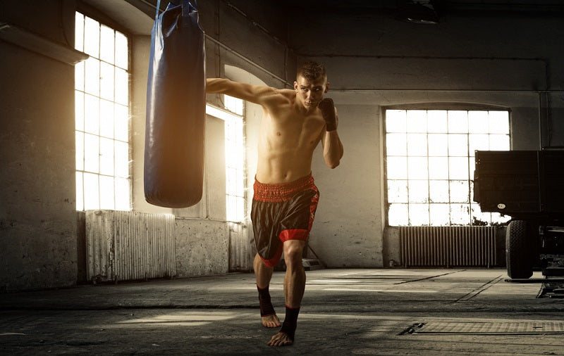 young man punching a boxing heavy bag