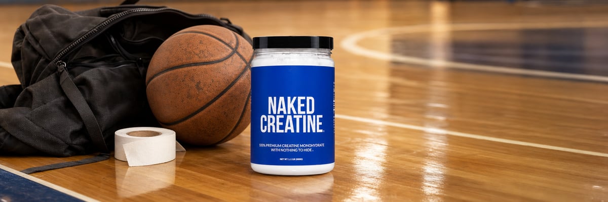 Naked Creatine tub on a basketball court sideline next to a sports bag and basketball