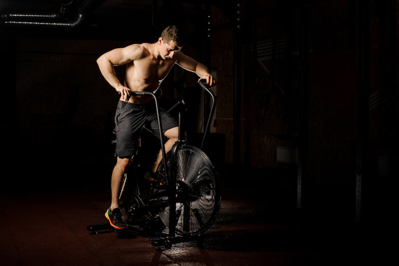 fit young man on assault bike