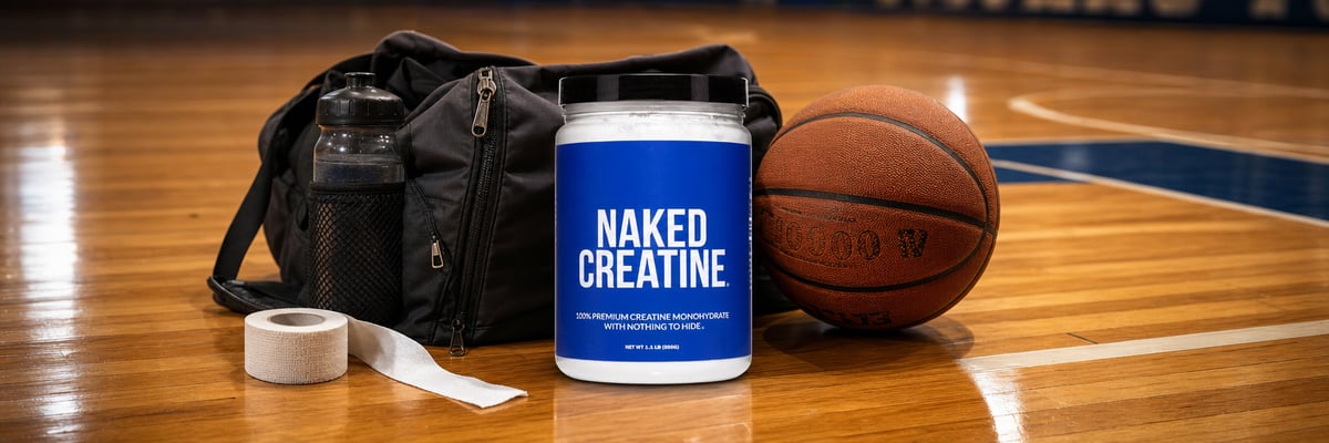 Naked Creatine tub on basketball court sideline beside athletic bag and basketball